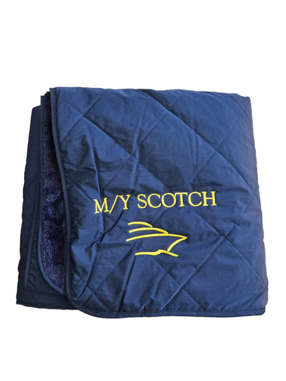 Folded blue blanket with 'MY SCOTCH' embroidered with a boat logo